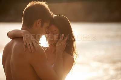 Buy stock photo A young couple sharing a romantic moment while on a beach