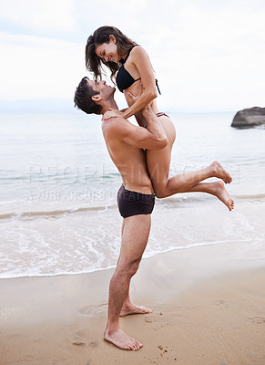 Buy stock photo Playing, embrace and couple on beach with waves, travel adventure and relax on summer island holiday. Ocean vacation, woman and man hug in nature on date together with smile, love and romance in Bali