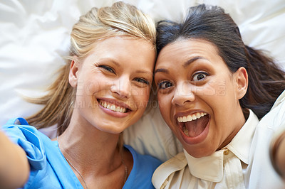 Buy stock photo Women, selfie and smiles by friends on bed for profile picture, app and social media network for fun. Diverse, young and excited together in room for crazy and silly memories to bond for friendship