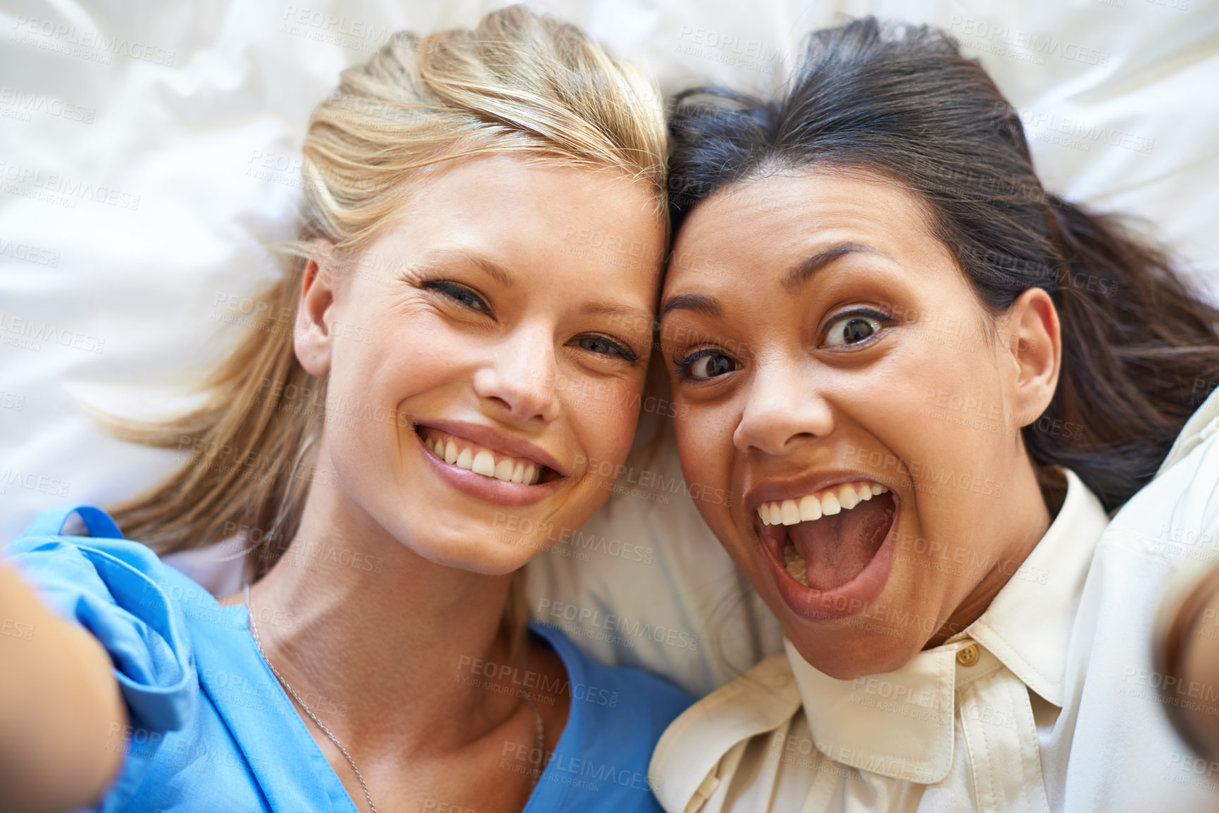 Buy stock photo Women, selfie and smiles by friends on bed for profile picture, app and social media network for fun. Diverse, young and excited together in room for crazy and silly memories to bond for friendship