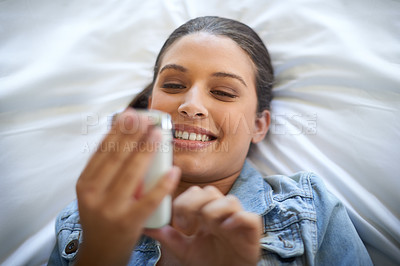Buy stock photo Relax, woman and smile with cellphone on bed for social media, reading message or browse on internet. Female person, happy and technology in home for communication, web search or scroll on website
