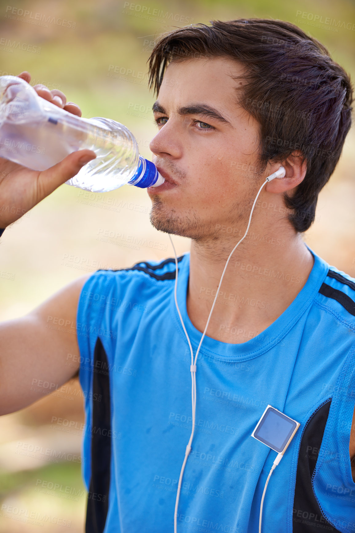 Buy stock photo Male athlete, running and water break with earphones, nature and hiking for fitness and wellness. Marathon runner, for race with podcast, thinking of sport and exercise for health and vitality