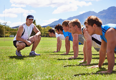 Buy stock photo Young sportsmen training outdoors with a coach