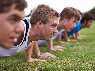 Buy stock photo Shot of a group of young sportsmen training outdoors