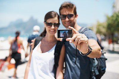 Buy stock photo Shot of a young couple taking a self-portrait at the beach