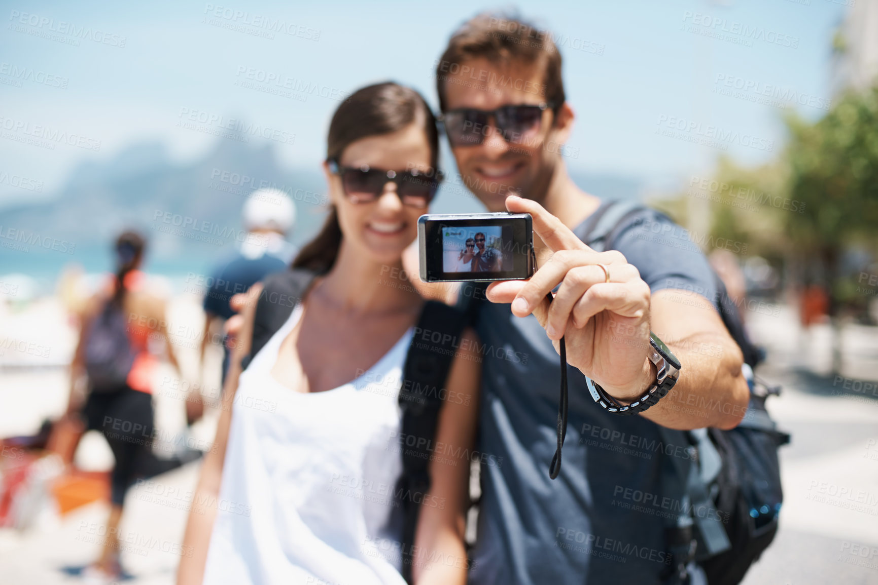 Buy stock photo Shot of a young couple taking a self-portrait at the beach