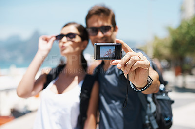 Buy stock photo Happy couple, smile and travel with camera for selfie, sunglasses and backpack outdoor. People, man and woman on adventure for break or holiday, trip and memories in relationship together