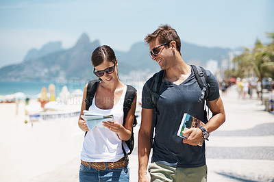 Buy stock photo Couple, tourist and beach with map for guide on holiday, tour and travel for summer in Rio de Janeiro. Relationship, vacation and happy in seaside for trip in adventure, together and smile for break