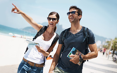 Buy stock photo Couple, holiday and pointing with map at beach as tourist in summer, trip and smile for adventure in Brazil. Directions, relationship and bonding on vacation in seaside for travel, break and happy 