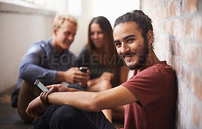 Buy stock photo Shot of three students relaxing in the hallway