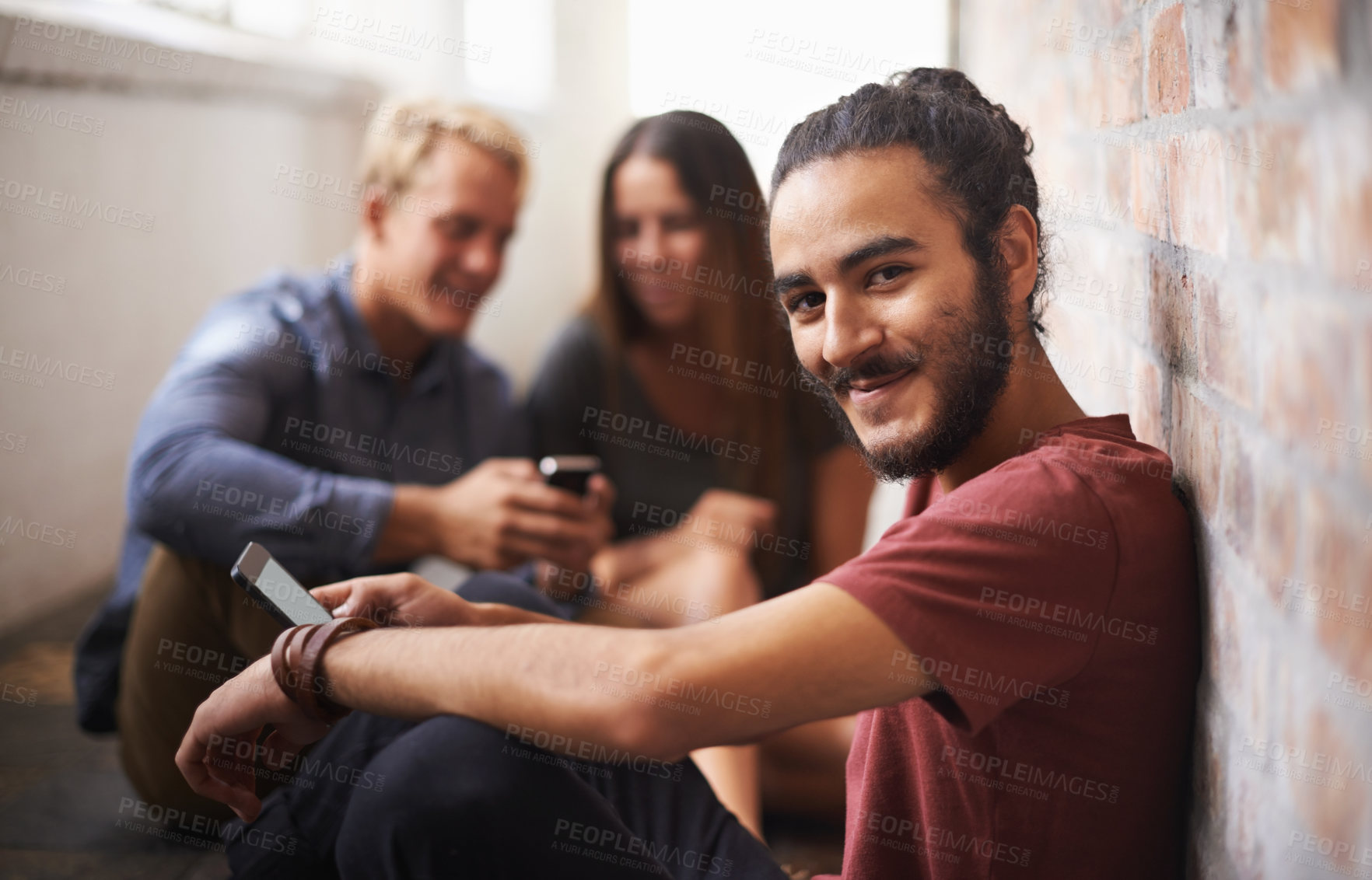 Buy stock photo Shot of three students relaxing in the hallway