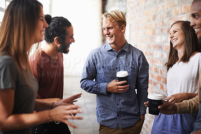 Buy stock photo Shot of a diverse group of friends making conversation in a hallway