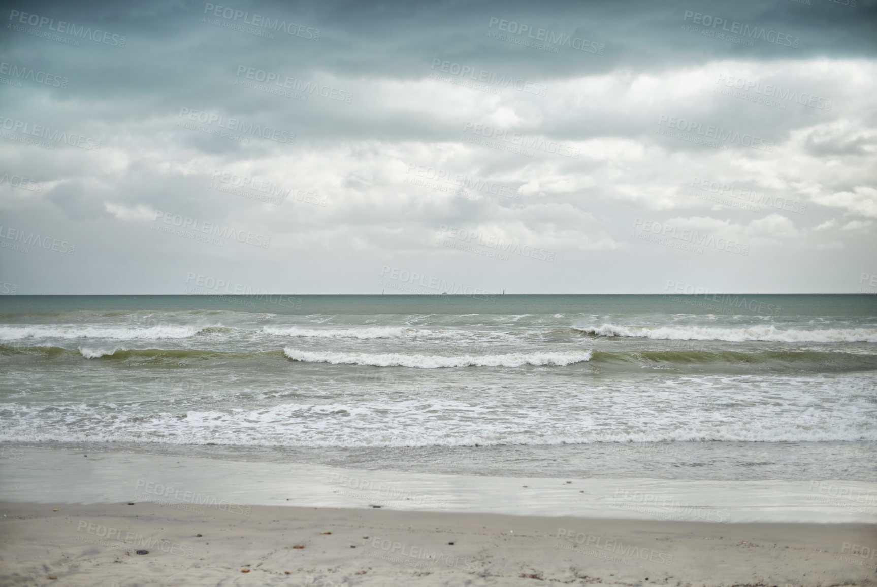 Buy stock photo Landscape shot of a beach on a cloudy day