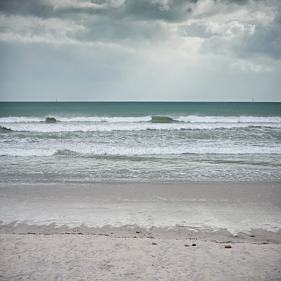 Buy stock photo Landscape shot of a beach on a cloudy day