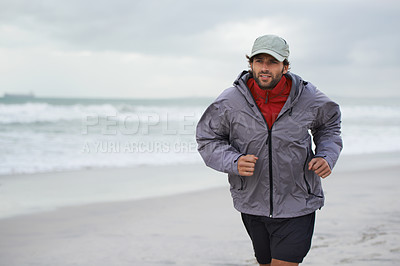 Buy stock photo Cropped shot of a handsome young man running on the beach