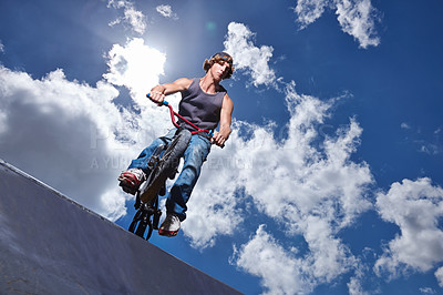 Buy stock photo Full length shot of a teenage boy riding a BMX at a skatepark