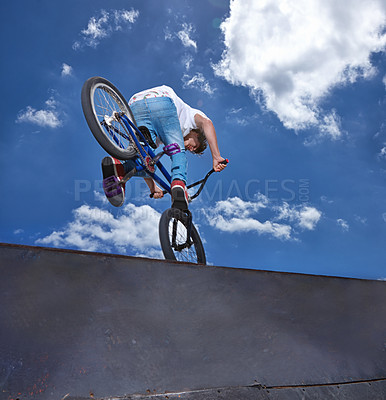 Buy stock photo Rearview shot of a teenage boy riding a BMX at a skatepark