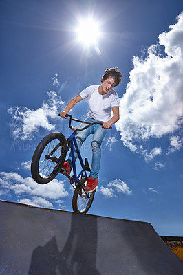 Buy stock photo Ride, bike and teenager on ramp for sport performance, jump or training for event at park with blue sky mockup. Bicycle, stunt or balance on edge of board in trick for cycling competition challenge