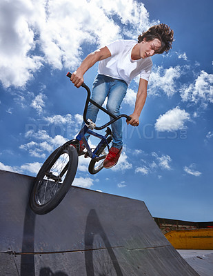 Buy stock photo Bike, jump and teen on ramp for sport performance, ride or training for event at park with sky. Bicycle, stunt or kid balance on edge of board for cycling trick in competition or challenge with risk