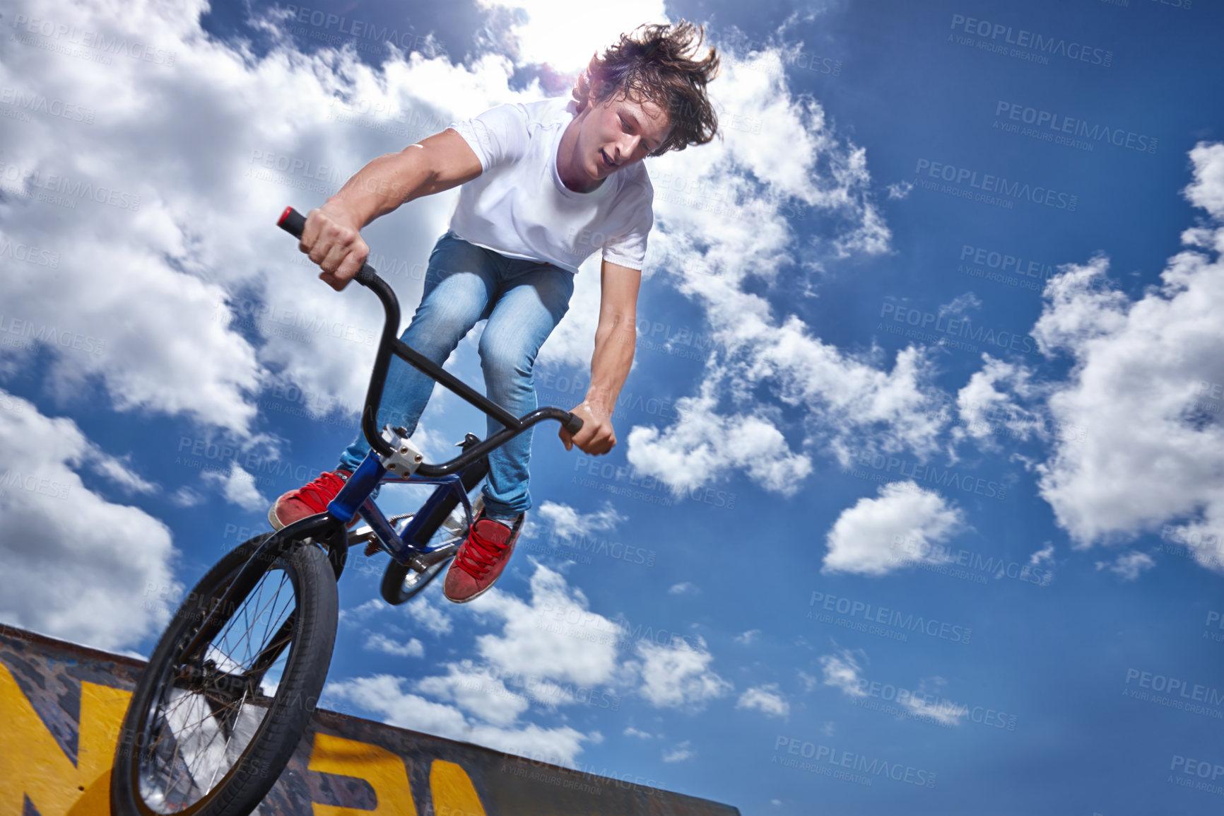 Buy stock photo Bike, jump and teen on ramp for sport performance, ride or training for event at park with sky. Bicycle, stunt or kid balance on edge of board for cycling trick in competition or challenge with risk
