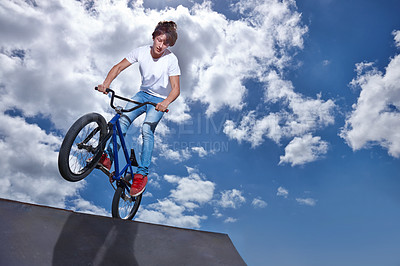 Buy stock photo Riding, bike and teen on ramp for sport performance, jump or training for event at park with blue sky mockup. Bicycle, stunt or kid balance on edge of board in trick for cycling competition challenge