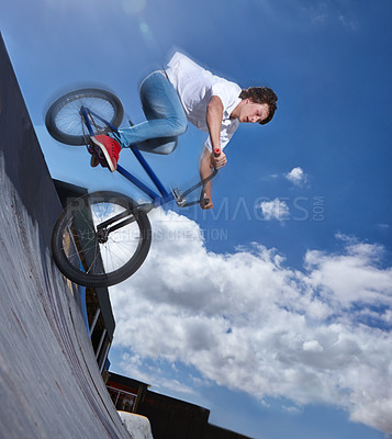 Buy stock photo Bike, ride and teenager with speed on ramp at skatepark in summer with freedom and energy on blue sky. Fast, bicycle and performance of stunt with kid in competition, contest or event for cycling