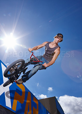 Buy stock photo Bike, jump and man on ramp for sport performance, ride or training for summer event at park with sky. Bicycle, stunt or person on edge of board for cycling trick in competition or challenge with risk