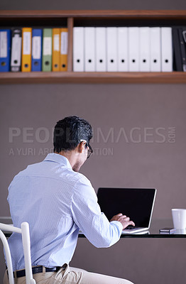 Buy stock photo Cropped shot of a handsome young businessman working at his desk