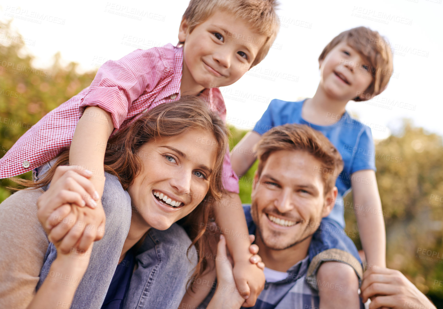 Buy stock photo Happy, nature and children on parents shoulders in outdoor park or field for playing together. Smile, bonding and portrait of young mother and father carrying boy kids for fun in garden in Canada.