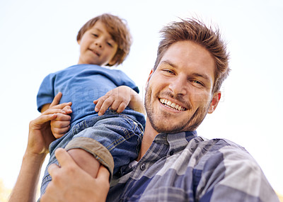 Buy stock photo Portrait of a young father carrying his son on his shoulders