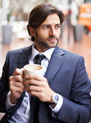 Buy stock photo A thoughtful businessman drinking coffee outdoors at a coffee shop