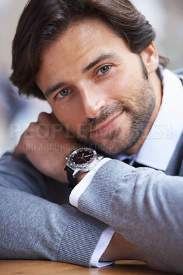 Buy stock photo A cropped portrait of a handsome businessman leaning on a table
