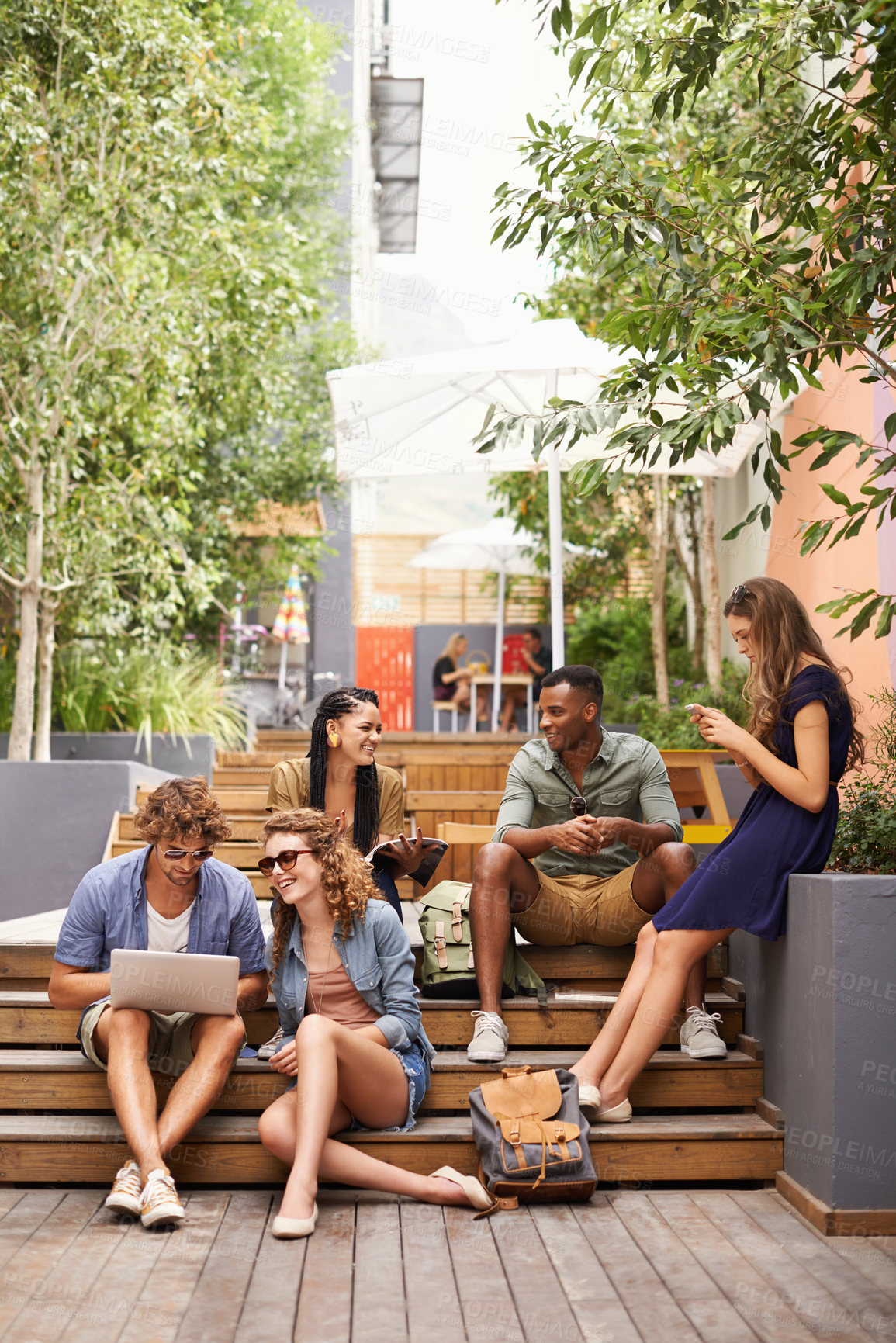 Buy stock photo Friends, happy and laptop or relax on break, campus and browse on social media for class update. Students, diversity or technology in college for online research and talking or phone for networking