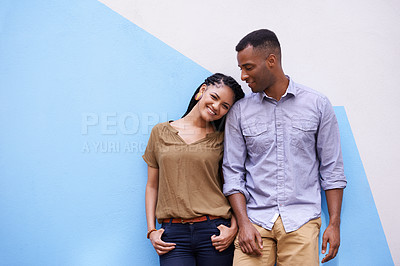 Buy stock photo Portrait shot of a young couple leaning against a colorful wall