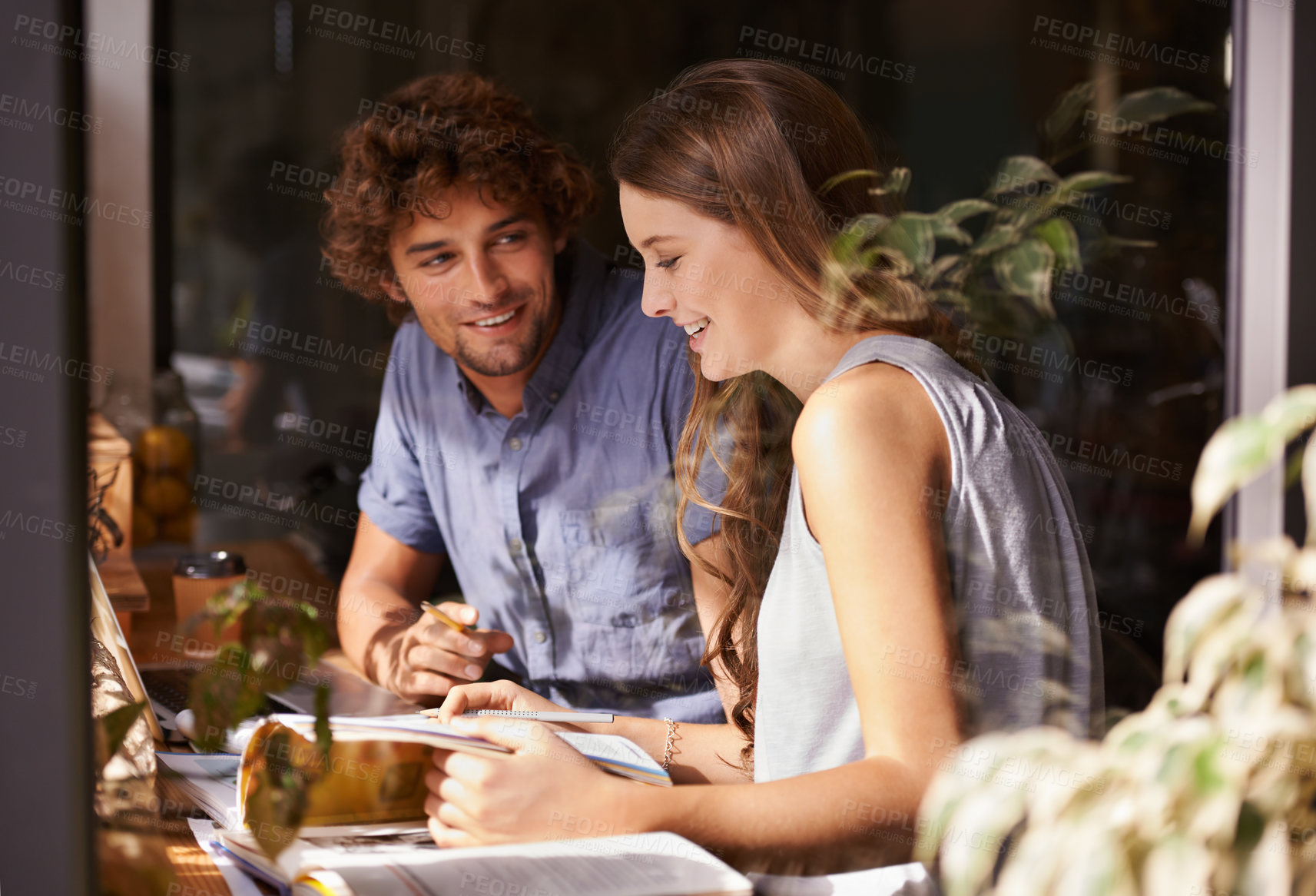 Buy stock photo Shot of two young students doing revision in a coffee shop