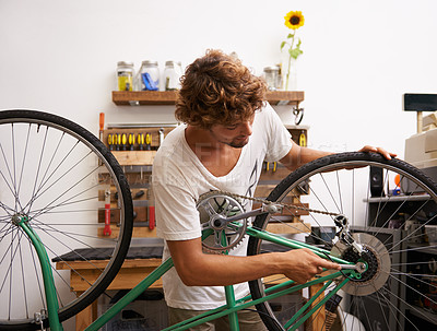 Buy stock photo Small business, startup and bike repair with man mechanic in workshop for service or maintenance. Entrepreneur, handyman or technician working on bicycle to fix chain, gear and wheel for occupation