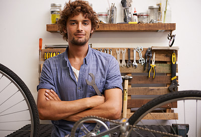 Buy stock photo Shot of a confident young bicycle repairman looking at the camera
