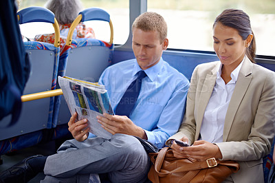 Buy stock photo Business people, man and woman in bus or public transport  for travel and commute outdoors against blurred background. Colleagues, working partners with newspaper  and phone for thinking on trip  