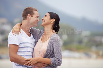 Buy stock photo Love, romance and dating for couple at beach for leisure,  bonding or vacation. Partners, mates and relationship with smile and hug for kiss and affection against blurred background and mockup