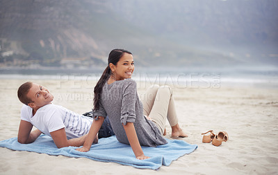 Buy stock photo Rearview shot of a young couple looking back at the camera while on the beach