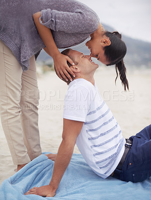 Buy stock photo Shot of a young woman kissing her boyfriend on the beach