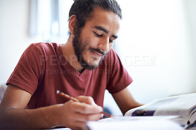 Buy stock photo University, student and man reading textbook for education with scholarship, smile and studying. Male person, happy and learning for information with research on table or desk of classroom in academy
