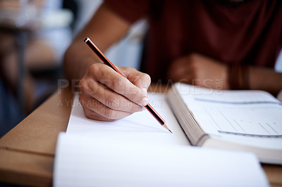Buy stock photo Closeup shot of a young student writing on a note pad