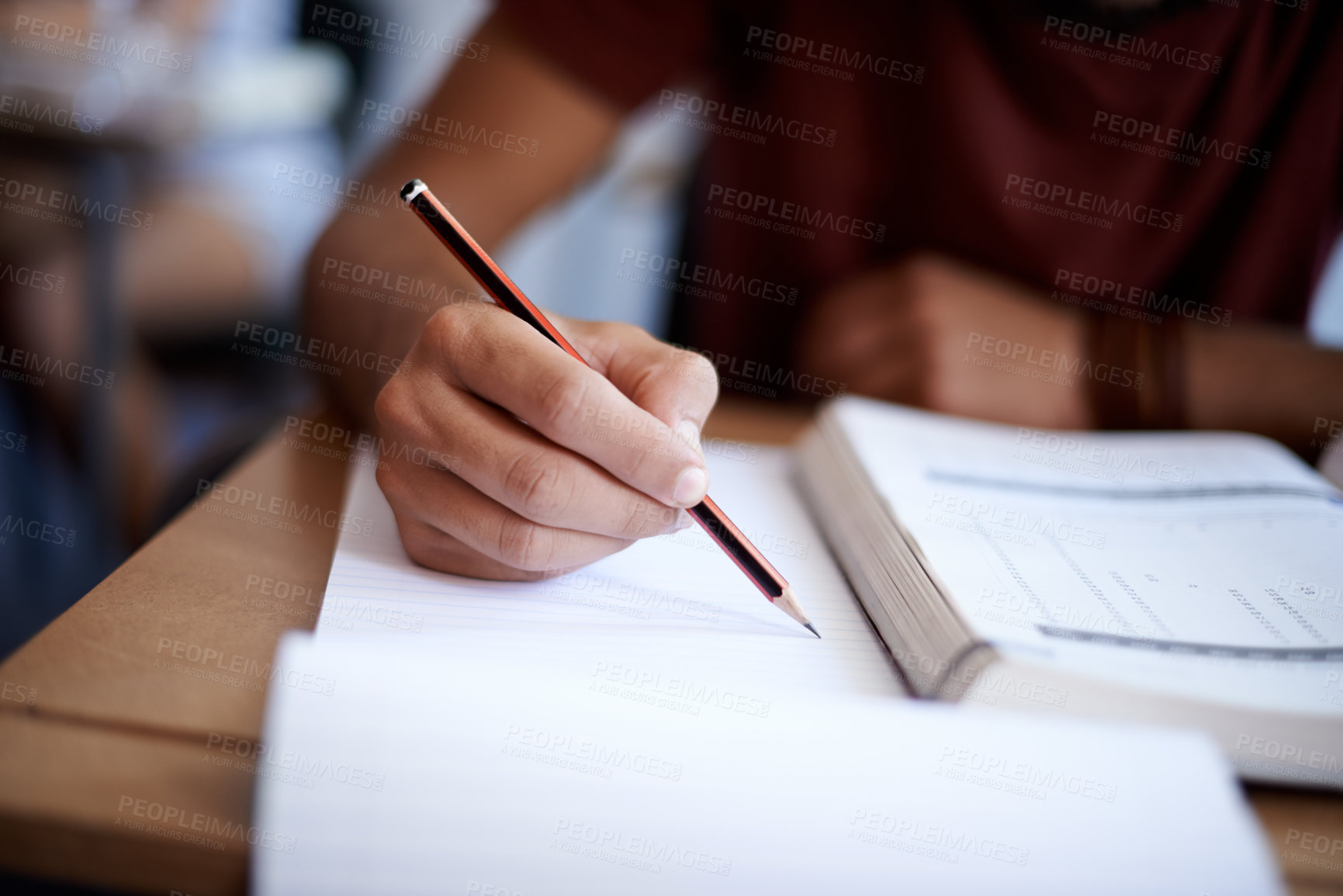 Buy stock photo Closeup shot of a young student writing on a note pad