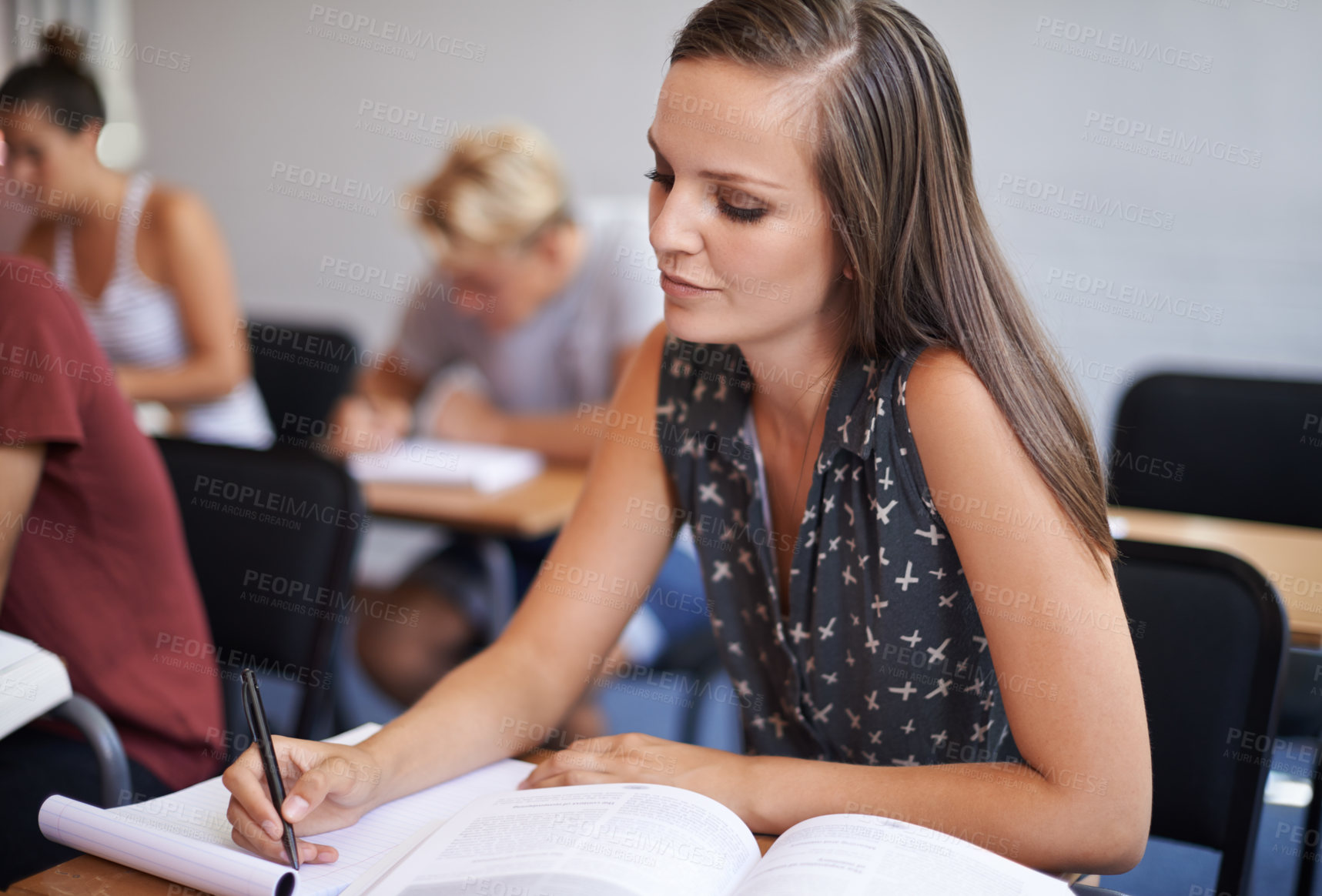 Buy stock photo College student, writing and desk in classroom with textbook for english literature or language for exam. Female person, university and scholarship for learning or education, knowledge and studying.