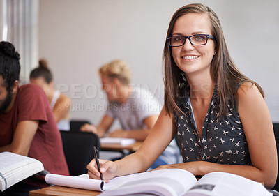 Buy stock photo An attractive young varsity student sitting in a classroom with a textbook in front of her