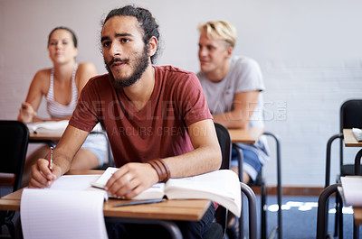 Buy stock photo Man, students and classroom with thinking, writing and listening to lecture with education, notes and ideas at desk. Person, learning and assessment with books, pen or attention to study at college