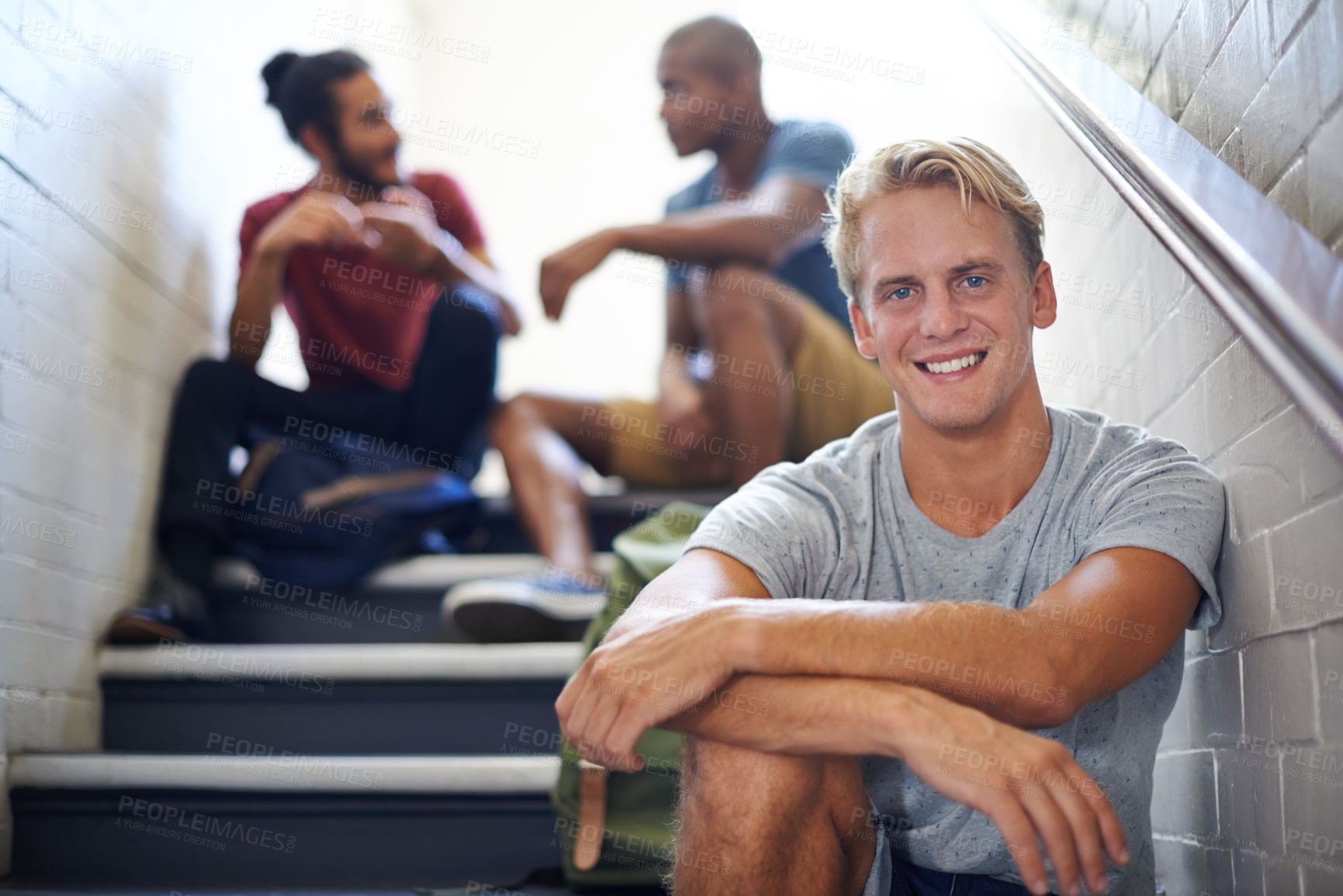 Buy stock photo Portrait, student and man with friends on stairs of college with backpacks, hangout and happiness. Steps, male person and relax with smile in university with people, gen z and scholarship for guy