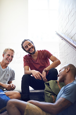 Buy stock photo Shot of male university students sitting and talking before class