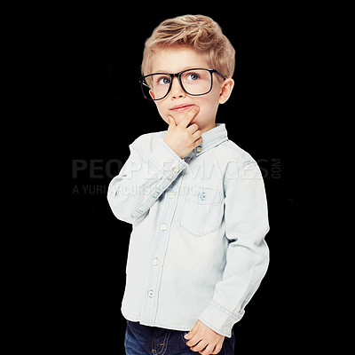 Buy stock photo Child, boy and thinking on eye care in studio, lenses and glasses for eyesight and frame choice. Male person, kid and optometry or contemplating decision for style, spectacles and black background